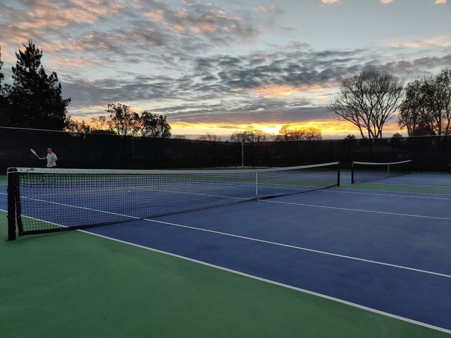 Boothbay Park tennis courts at sunset, with dark windscreens on the fence.