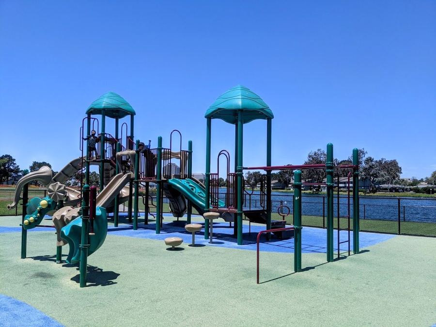 Catamaran Park playground with the lagoon behind it. This listing has no close-up of the tennis courts.
